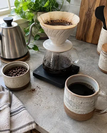 a finished project on a counter set up for pour-over brewing, a counter set up for pour-over brewing, soft window light